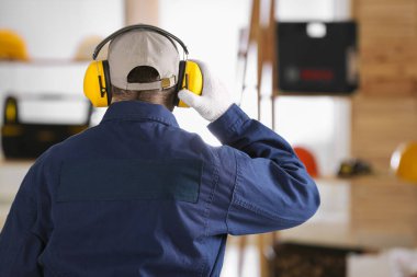 İçeride güvenlik kulaklığı takan bir işçi. İşitme koruma aygıtı
