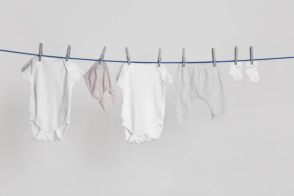 Different Baby Clothes Drying Laundry Line Light Background — Stock Fotó