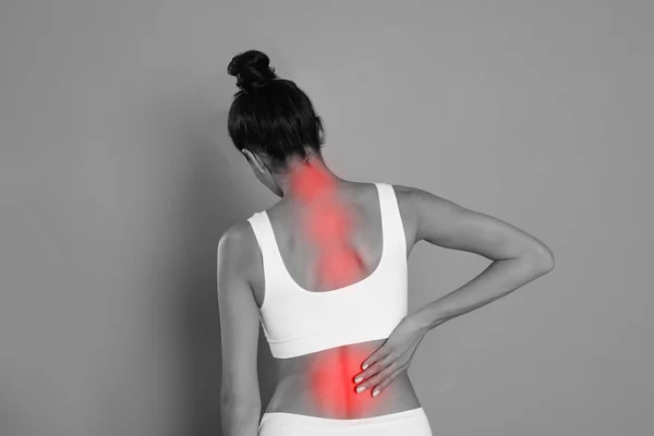 Mujer Que Sufre Dolor Espalda Sobre Fondo Gris —  Fotos de Stock