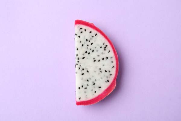 Slice of delicious dragon fruit (pitahaya) on violet background, top view