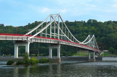 KYIV, UKRAINE - AUGUST 11, 2022: Beautiful cityscape with pedestrian Park bridge over Dnipro river