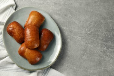 Açık gri masada nefis pişmiş pirozhki, üst manzara. Metin için boşluk