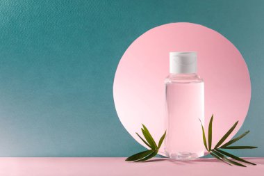 Micellar water on pink background. Stylish presentation of cosmetic product