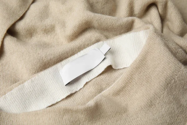 Warm beige cashmere sweater with clothing label, closeup