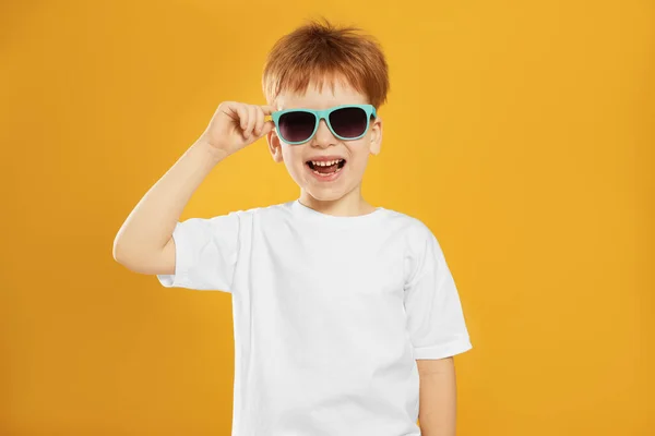 可爱的小男孩 戴着黄色背景的太阳镜 — 图库照片