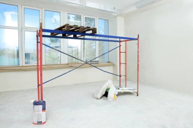 Boş odadaki iskele tadilat için hazırlanıyor.