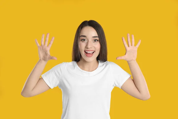 Kvinna Vit Shirt Visar Nummer Tio Med Händerna Gul Bakgrund — Stockfoto