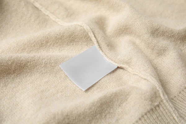 Warm beige cashmere sweater with clothing label, closeup