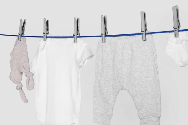 Different Baby Clothes Drying Laundry Line Light Background Closeup — Stock Fotó