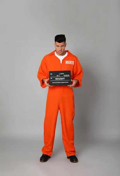 Häftling Orangefarbenem Overall Mit Mugshot Schriftzug Auf Grauem Hintergrund — Stockfoto