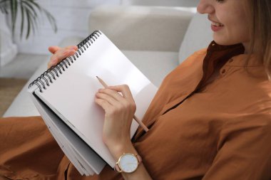 Çizim defterinde kalemle çizen kadın, yakın plan.