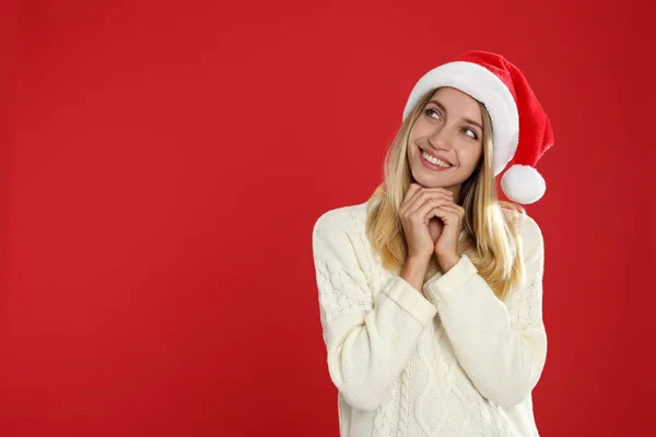 Happy woman in Santa hat on red background, space for text. Christmas countdown