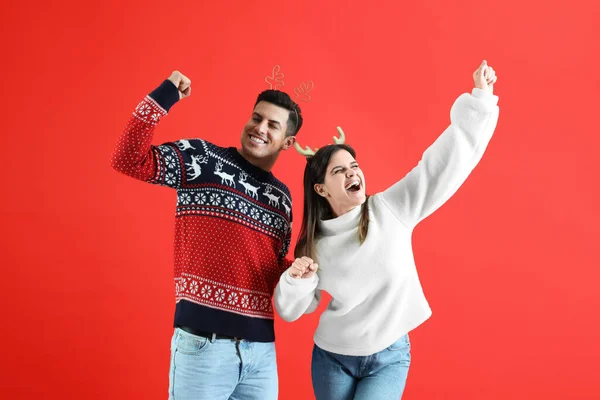 Belo Casal Feliz Faixas Natal Blusas Divertindo Fundo Vermelho — Fotografia de Stock