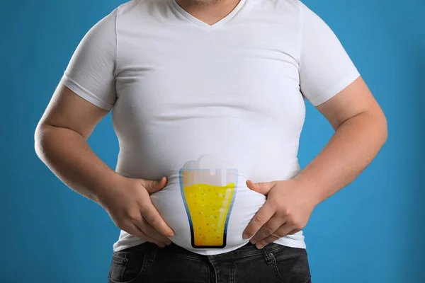 Beer belly problem. Overweight man on blue background, closeup