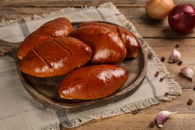 Lezzetli pirozhki, sarımsak ve ahşap masada biber.