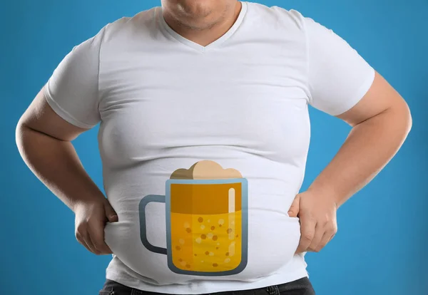 Beer belly problem. Overweight man on blue background, closeup