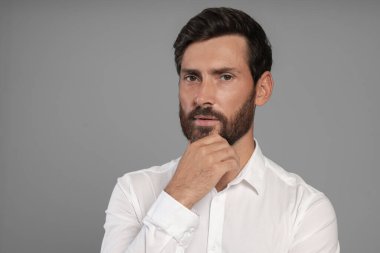 Gri arka planda yakışıklı sakallı adamın portresi, metin için boşluk