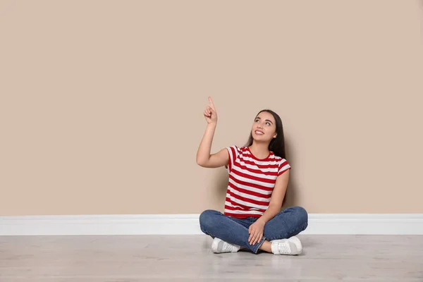 Mujer Joven Sentada Suelo Cerca Pared Beige Interior — Foto de Stock