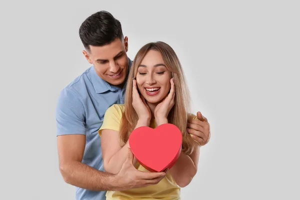 Man Surprising His Girlfriend Gift Grey Background Valentine Day Celebration — Stock Photo, Image