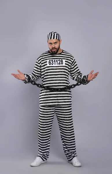 灰色の背景に鎖手で特別な制服を着た囚人 — ストック写真