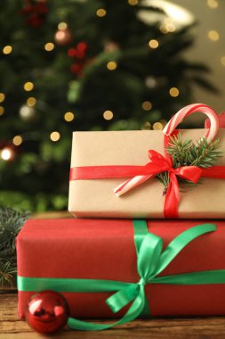 Güzel hediye kutuları ve Noel dekoru ahşap masada, yakın plan.