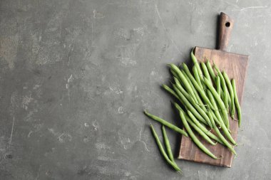 Taze yeşil fasulyeler gri masada, düz yerde. Metin için boşluk