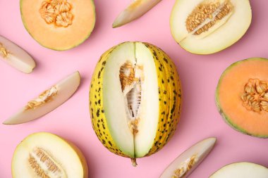 Renkli olgun kavunlar pembe arka planda, düz yerde