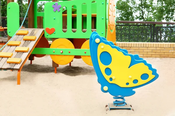 儿童游乐场上的新蝴蝶形春车和五彩缤纷的火车玩具 — 图库照片