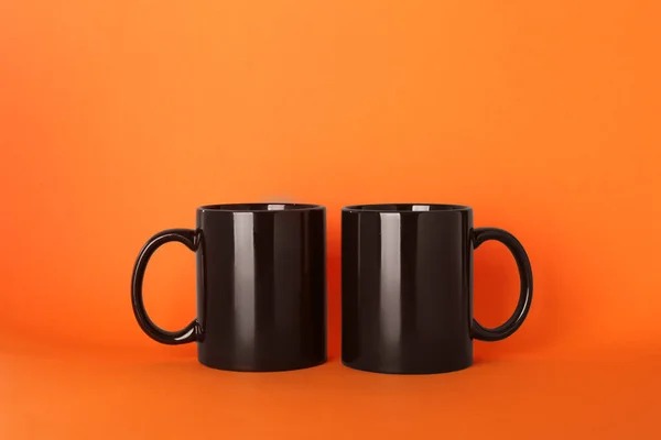 橙色背景的空白黑色陶瓷杯 — 图库照片