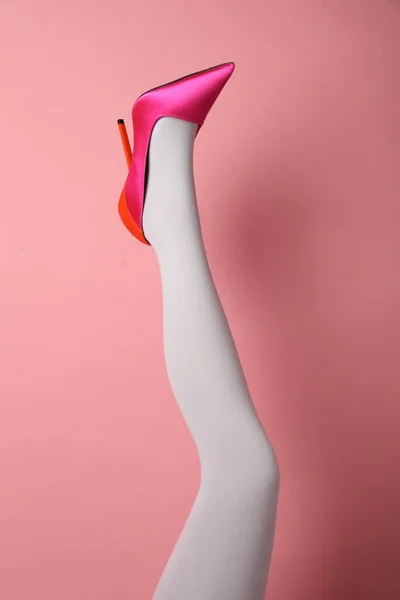 ピンクの背景に白いタイツとハイヒールの靴を履いた女性 クローズアップ — ストック写真