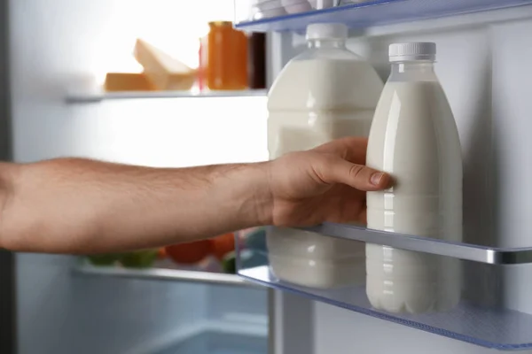 Man taking gallon of milk from refrigerator, closeup