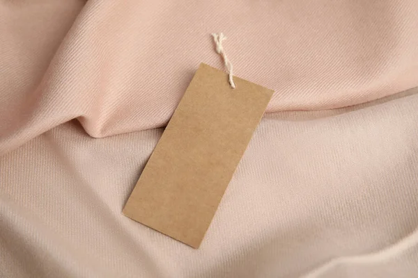 Warm beige cashmere garment with tag, closeup