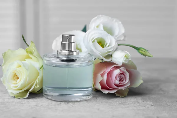 Bottle Perfume Flowers Grey Table Indoors — Zdjęcie stockowe