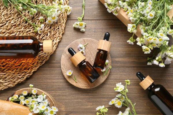 Flache Lagekomposition Mit Ätherischem Kamillenöl Und Blüten Auf Holzgrund — Stockfoto