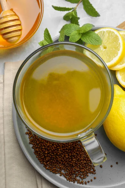 Buckwheat tea, lemon and honey on light grey marble table, flat lay