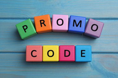 Açık mavi ahşap masadaki renkli küplerden oluşan kelime tanıtım kodu.