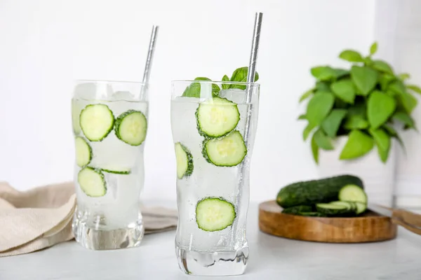 Tasty fresh cucumber water on white table