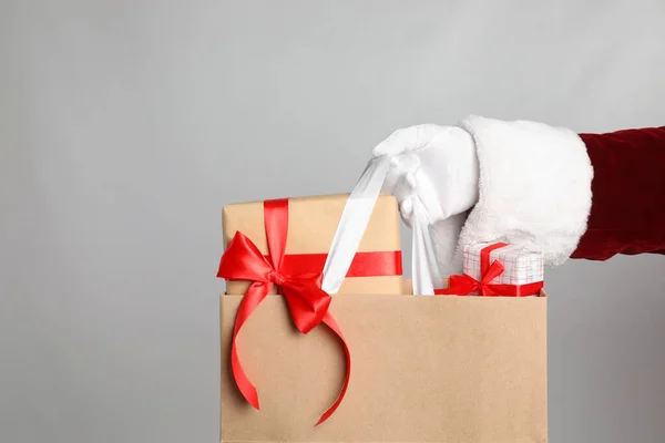 Santa Segurando Saco Papel Com Caixas Presente Fundo Cinza Claro — Fotografia de Stock