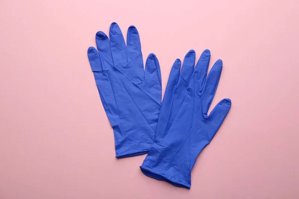 ピンクの背景に医療用手袋のペア フラットレイアウト — ストック写真