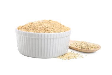 Seramik kasede susam unu ve beyaz üzerine izole edilmiş tohumlar.