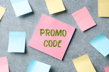 Kağıt notta açık gri masa üzerinde tanıtım kodu, düz yatıyordu