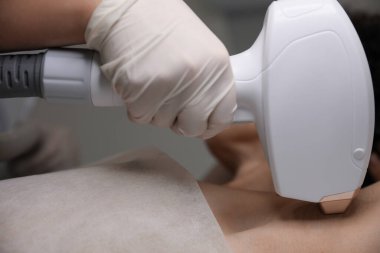 Woman undergoing laser epilation procedure, closeup view