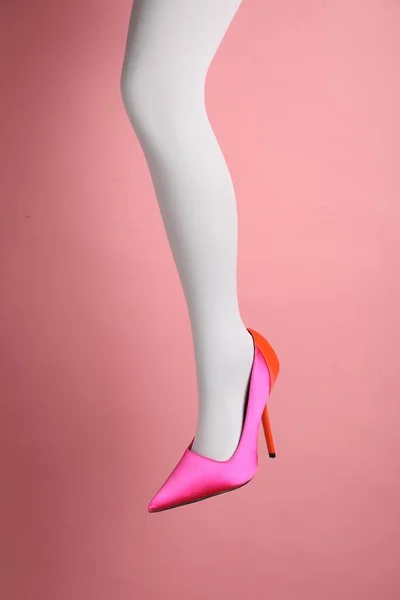 ピンクの背景に白いタイツとハイヒールの靴を履いた女性 クローズアップ — ストック写真