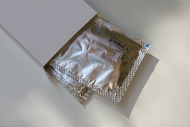 Tek dozda göz damlası olan paket beyaz masanın üzerinde, görüntünün üstünde.