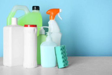 Masada açık mavi arkaplan ve metin için farklı temizlik malzemeleri ve araçları