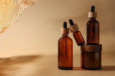 Koyu bej arka planda farklı lüks kozmetik ürünleri ile set, metin için alan