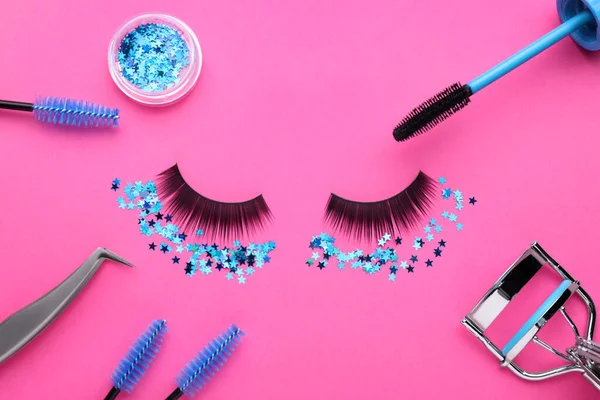 Flat lay composition with false eyelashes on pink background