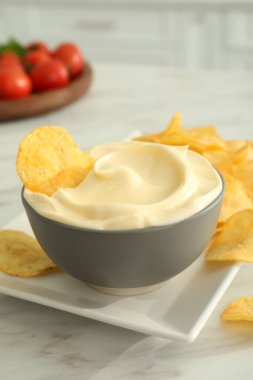 Beyaz mermer masada patates cipsi ve mayonez.