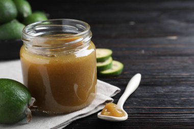 Feijoa reçeli ve siyah ahşap masada taze meyve, yakın plan. Metin için boşluk