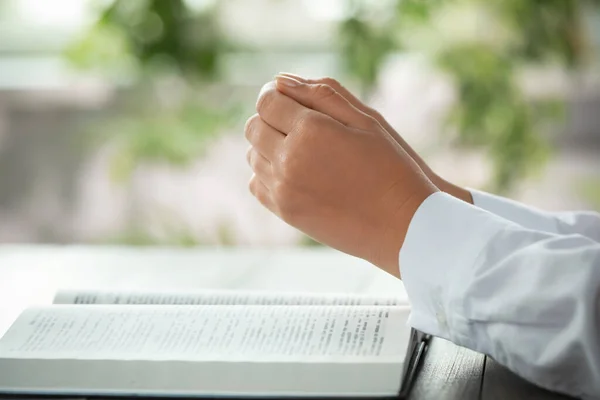 Γυναίκα Κρατώντας Χέρια Σφιγμένα Ενώ Προσεύχεται Γκρι Τραπέζι Βίβλο Closeup — Φωτογραφία Αρχείου